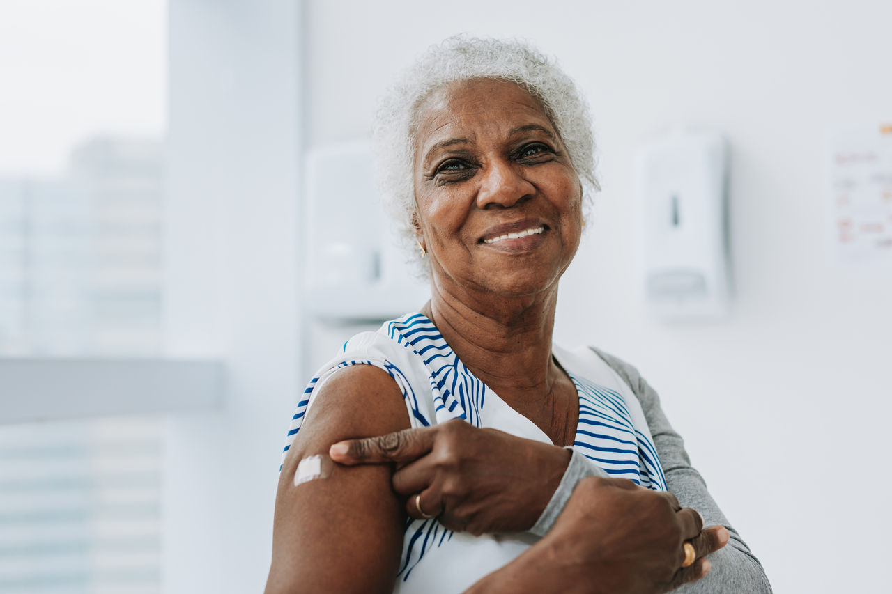 Portrait of a senior woman showing that she has been immunized with the vaccine