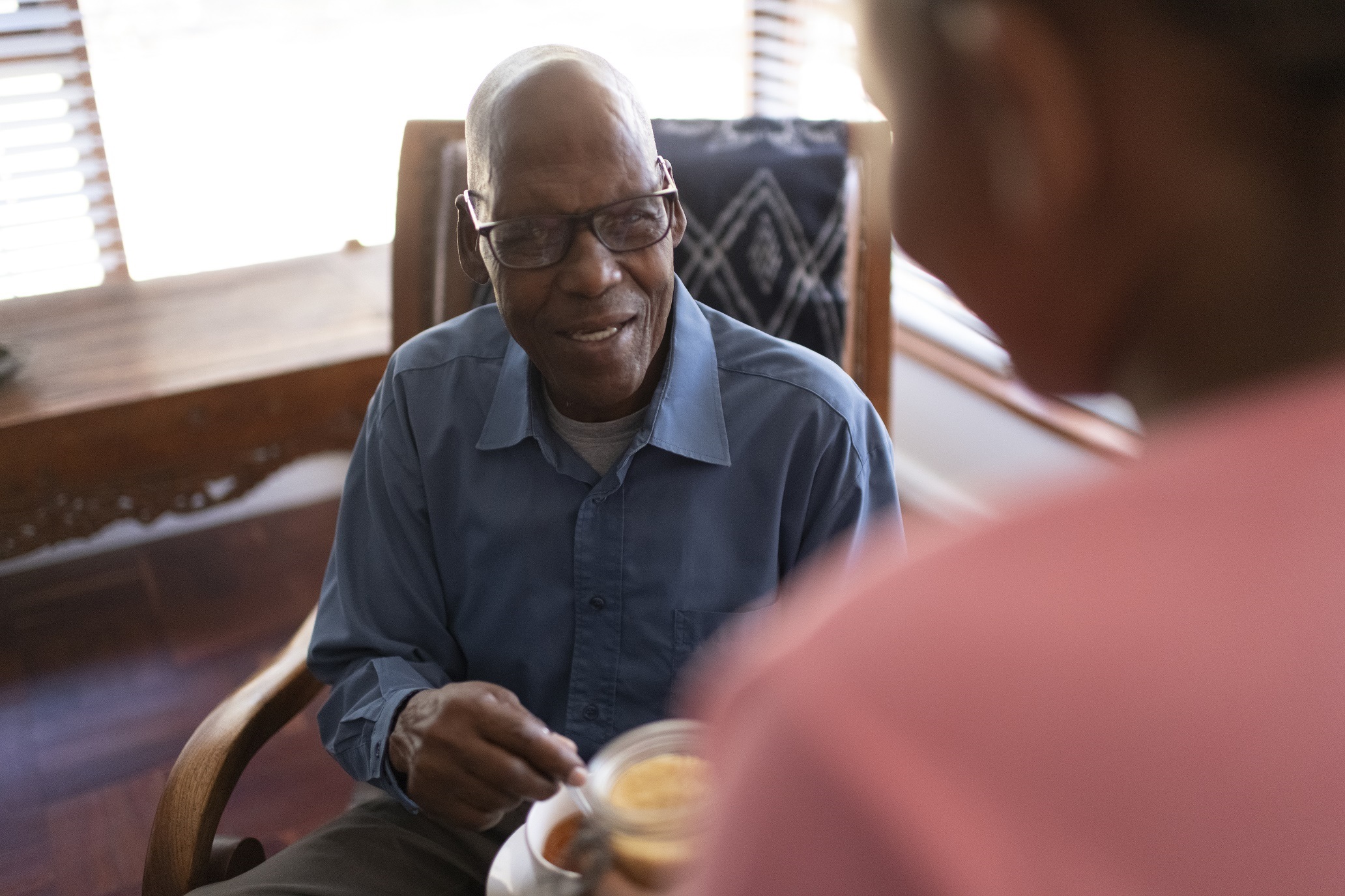 Granddaughter offers grandfather sugar for his tea